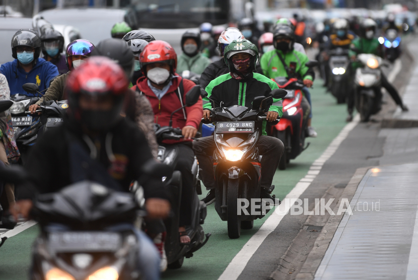 Pengendara motor mengenakan masker saat melintas di Jalan MH Thamrin, Jakarta, Rabu (12/1/2022). Kemenkes memprediksi puncak penyebaran kasus COVID-19 varian Omicron akan terjadi pada awal atau pertengahan Februari 2022. 