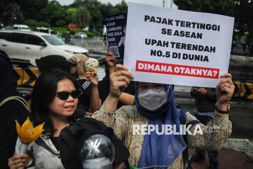 Sejumlah orang melakukan aksi  demonstrasi di seberang Istana Merdeka, Jakarta, Kamis (19/12/2024). Dalam aksinya mereka menolak kenaikan Pajak Pertambahan Nilai (PPN) 12 persen pada 2025. Menurut mereka kenaikan PPN tersebut akan tetap memberatkan masyarakat karena berpengaruh terhadap kenaikan harga.