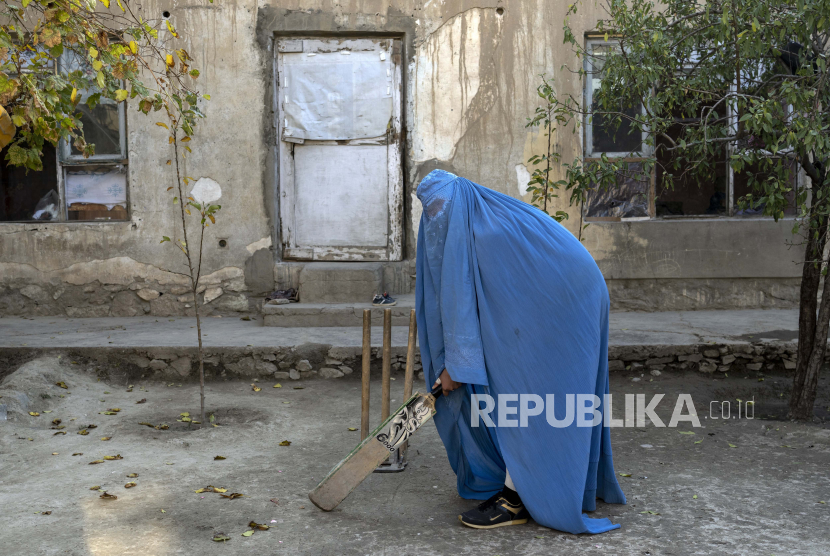 Seorang wanita Afghanistan berfoto dengan tongkat kriketnya di Kabul, Afghanistan, Jumat, 11 November 2022. Taliban yang berkuasa telah melarang wanita berolahraga serta melarang mereka bersekolah dan bekerja. Sejumlah wanita berpose untuk seorang fotografer AP untuk dipotret dengan peralatan olahraga yang mereka sukai. Meskipun mereka tidak harus mengenakan burqa dalam kehidupan sehari-hari, mereka memilih untuk menyembunyikan identitas mereka dengan burqa karena mereka takut pembalasan Taliban dan karena beberapa dari mereka terus berlatih olahraga secara rahasia.