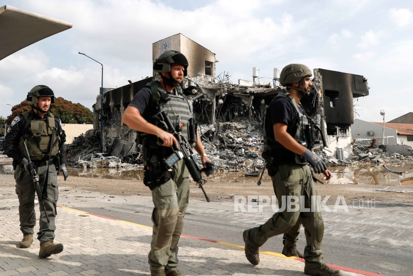 Pasukan keamanan Israel berjalan di luar kantor polisi yang hancur yang dikendalikan oleh militan Hamas di kota selatan Sderot, dekat perbatasan Gaza, Israel, 08 Oktober 2023.