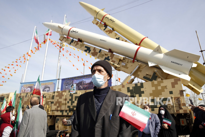 Seorang pria Iran berdiri di depan rudal Dezful dan Zolfaghar-Basir/
