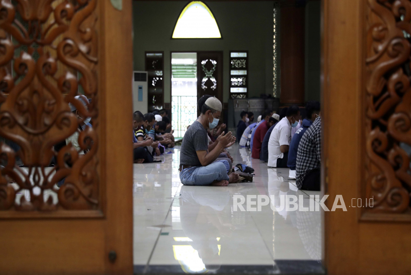 Allah Memperkenalkan Penghargaan Orang Berilmu. Seorang pria membaca kitab suci Alquran sambil menunggu waktu berbuka puasa di masjid Agung Al Barkah di Bekasi, Indonesia, Kamis, 15 April 2021. 