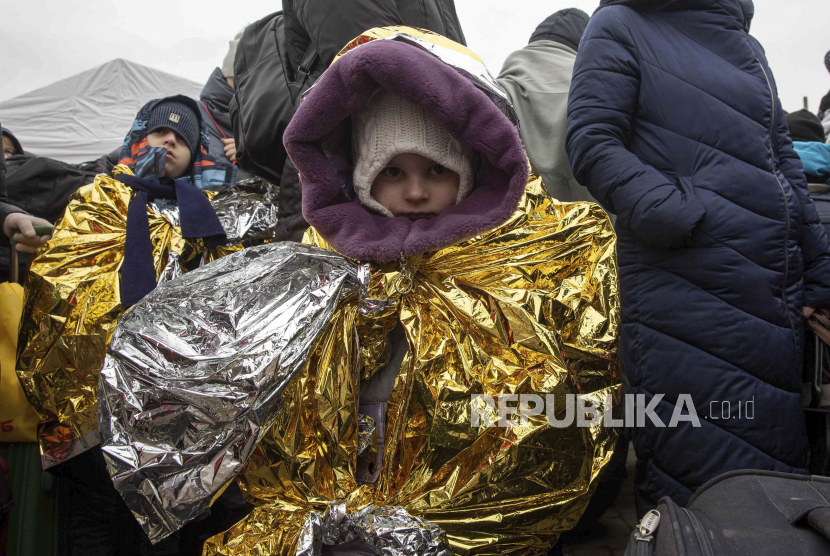 Anak-anak terbungkus selimut termal mencoba untuk tetap hangat setelah melarikan diri dari Ukraina dan tiba di perbatasan di Medyka, Polandia, Senin, 7 Maret 2022. Unicef: Lebih dari Satu Juta Anak Tinggalkan Ukraina Sejak Dimulainya Invasi Rusia