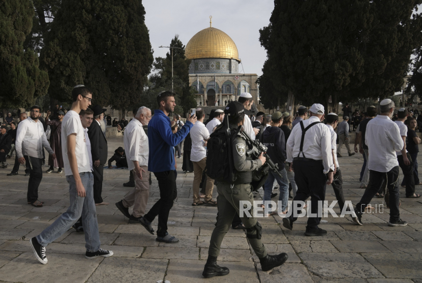 Polisi Israel mengawal pengunjung Yahudi yang menandai hari raya Paskah ke kompleks Masjid Al-Aqsa, yang dikenal umat Islam sebagai Tempat Suci Mulia dan bagi orang Yahudi sebagai Temple Mount, di Kota Tua Yerusalem selama bulan suci Ramadhan, Ahad (9/4/2023).