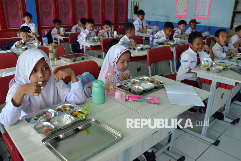 Para pelajar menikmati Makanan Bergizi Gratis (MBG) di SDN 193 Caringin, Sukajadi, Kota Bandung, Senin (6/1/2025). Pelaksanaan program makan bergizi gratis Badan Gizi Nasional ini dimulai secara bertahap di sekolah dasar hingga SMA guna memacu kualitas sarapan para pelajar.