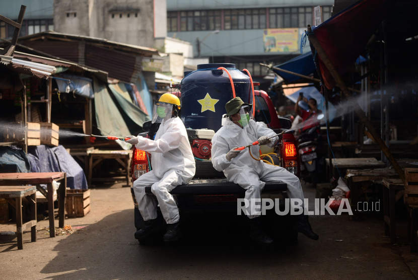 Petugas menyemprotkan cairan disinfektan di area Pasar Cisalak, Depok, Jawa Barat, (ilustrasi).