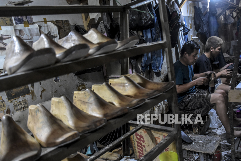 Pekerja menyelesaikan pembuatan sepatu, (ilustrasi).