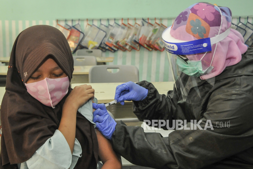 Petugas medis (kanan) menyuntikkan vaksin HPV (Human Papillomavirus) kepada Siswi Sekolah Dasar Negeri (SDN) 05 pada kegiatan bulan imunisasi di Pondok Kelapa, Jakarta Timur, Rabu (26/8/2020). Imunisasi yang diikuti siswi kelas V dan VI untuk mencegah infeksi virus HPV (human papillomavirus). 