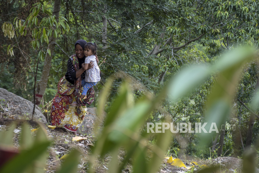Orang tua bersama anaknya bersiap menanam pohon durian di kawasan Gunung Sasak, Kabupaten Lombok Barat, Nusa Tenggara Barat, Selasa (29/11/2022). 