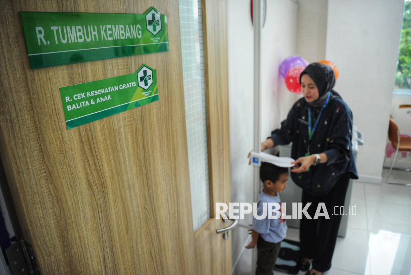 Petugas kesehatan melakukan pemeriksaan terhadap pasien anak di Puskesmas Tebet, Jakarta, Ahad (9/2/2025). KPAI meminta prosedur CKG dipermudah.