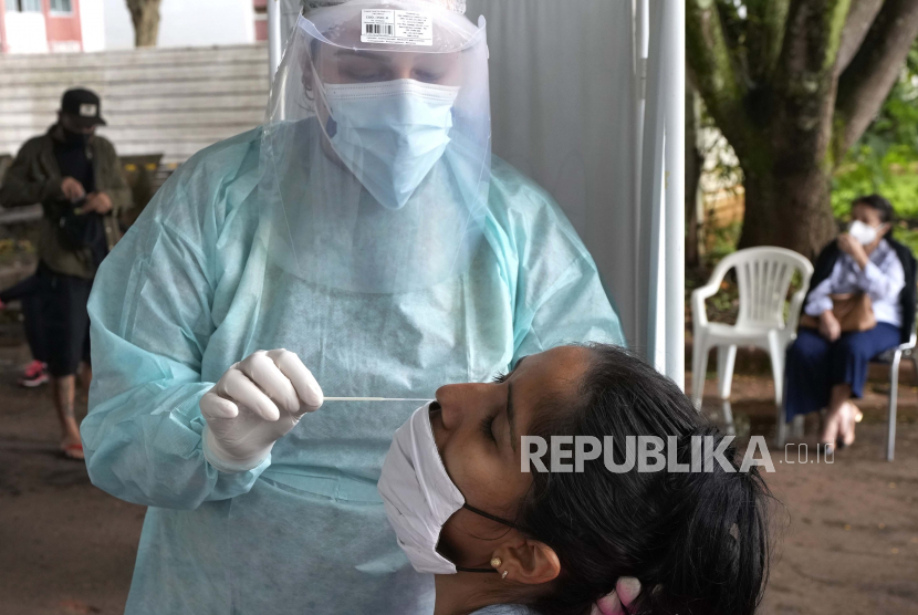 Seorang petugas kesehatan bersiap untuk melakukan sampel usap hidung untuk tes COVID-19 gratis dan cepat di pusat medis komunitas di Brasilia, Brasil, Senin, 10 Januari 2022. Brasil melaporkan rekor 137.103 kasus baru Covid-19 dalam 24 jam terakhir, Selasa (18/1) waktu setempat. 