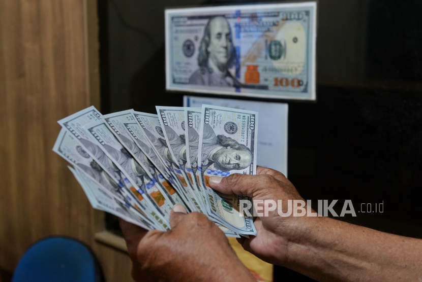 Petugas menunjukan uang dollar AS di Money Changer, Jakarta, Rabu (17/4/2024). 