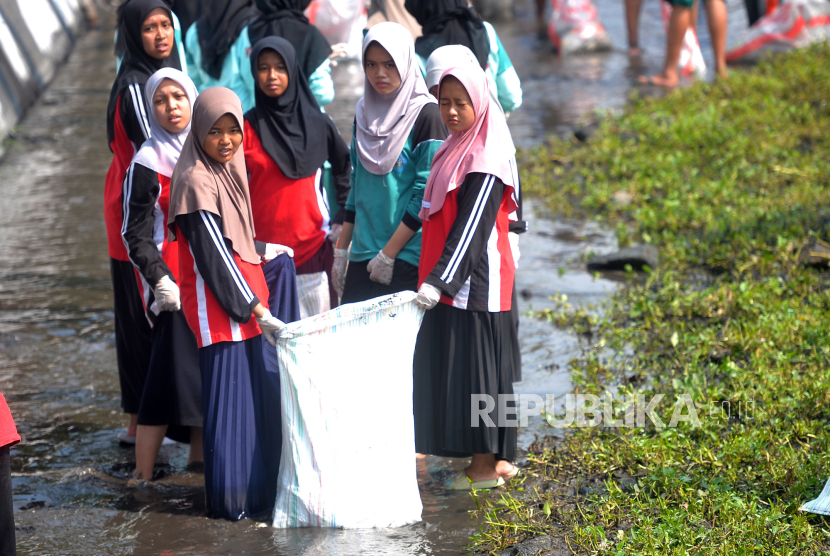 Santriwati mengikuti program kali bersih (Prokasih) Hari Santri Nasional 2023 pada salah satu sungai di Jejeran, Bantul, Yogyakarta, Selasa (24/10/2023). Sebanyak 300an santri serta pelajar membersihkan sampah sungai dalam rangka Hari Santri 2023. Santri berbaur dengan pelajar serta warga untuk menerapkan tanggung jawab sosial di masyarakat serta menekankan kebersihan lingkungan sekitar pesantren. Berbagai sampah anorganik dikumpulkan dalam karung, kemudian diangkut menggunakan truk sampah ke TPA.