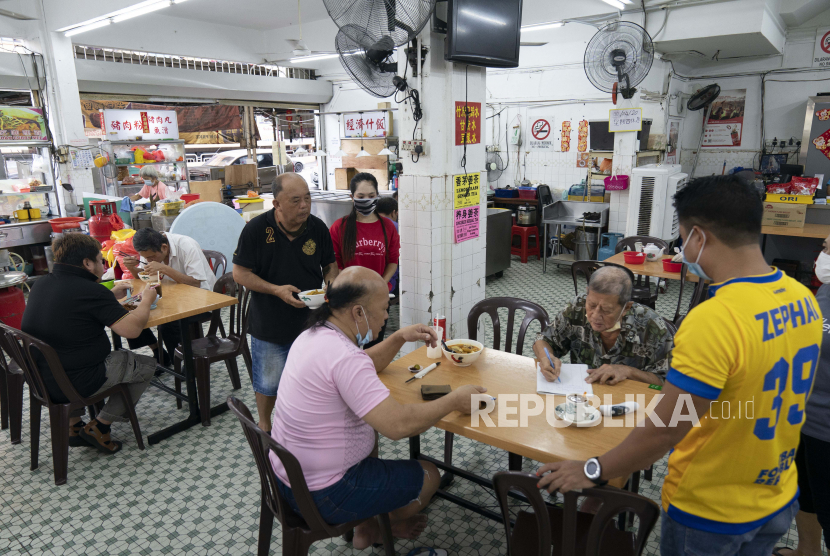 Sejumlah pelanggan menikmati sarapan di sebuah restoran lokal di Kuala Lumpur, Malaysia, Senin (4/5). Pemerintah Malaysia membatasi waktu operasi perniagaan mulai dari jam 08.00 hingga jam 20.00 berdasarkan Perintah Kawalan Pergerakan (PKP) 3.0 yang diberlakukan saat ini.