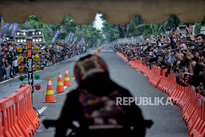 Warga menyaksikan ajang street race Polda Metro Jaya di Ancol, Jakarta Utara, Ahad (16/1/2022).
