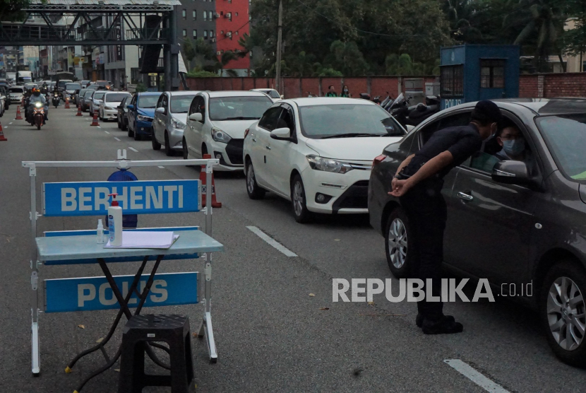 Petugas Kepolisian Diraja Malaysia (PDRM) melakukan pemeriksaan terhadap pengendara mobil yang masuk ke Kuala Lumpur di depan Kantor Polisi Tun HS Lee Jalan Loke Yew Kuala Lumpur, Kamis (19/3/2020). (Antara/Agus Setiawan)