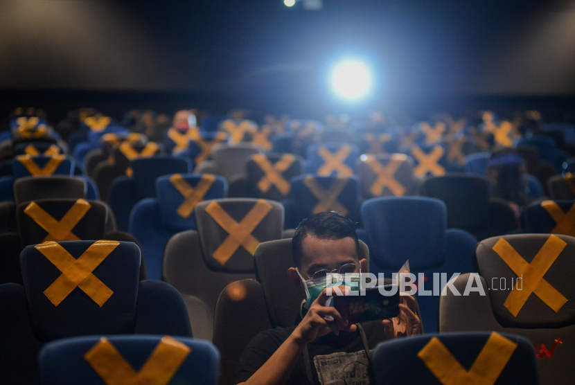Pengunjung menunggu tayangan film saat pembukaan perdana bioskop CGV Grand Indonesia pada masa PSBB transisi di Jakarta, Rabu (21/10). Jaringan bioskop CGV kembali membuka bioskopnya pada masa PSBB transisi dengan menerapkan protokol kesehatan seperti pengecekan suhu, pendataan pengunjung, penggunaan masker serta membatasi kapasitas pengunjung sebanyak 25 persen. Republika/Thoudy Badai
