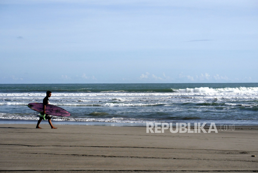 Warga setempat bermain papan selancar saat sepi pengunjung di Pantai Parangtritis, Bantul, Yogyakarta, Selasa (7/4). Penutupan Pantai Parangtritis sejak 21 Maret ini sebagai upaya pencegahan penyerbaran pandemi covid19