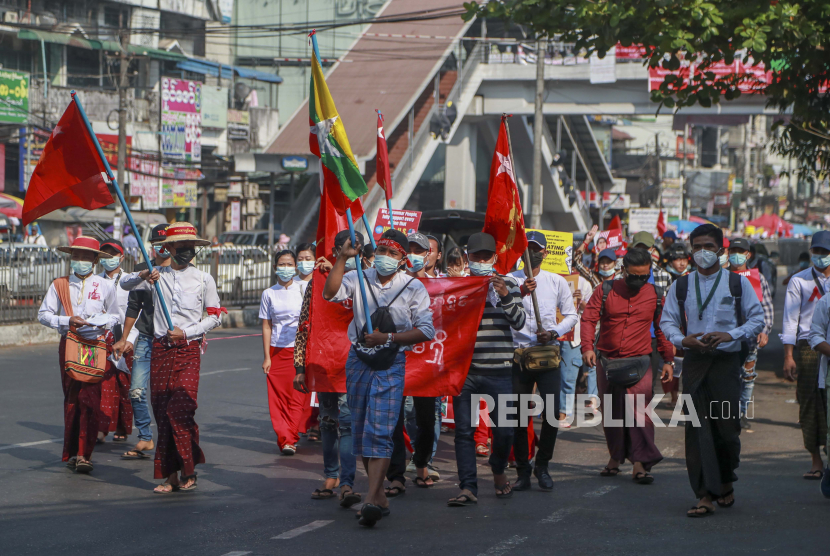  Pengunjuk rasa anti-kudeta membawa bendera partai Liga Nasional dan Nasional untuk Demokrasi selama unjuk rasa di Yangon, Myanmar, Rabu, 24 Februari 2021.