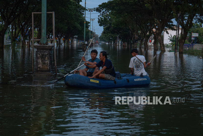 Warga menaiki perahu karet untuk menembus banjir yang mulai surut di jalur pantura Demak-Kudus. Menteri PUPR sebut perbaikan di dua titik tanggul Sungai Wulan Demak sudah diperbaiki.