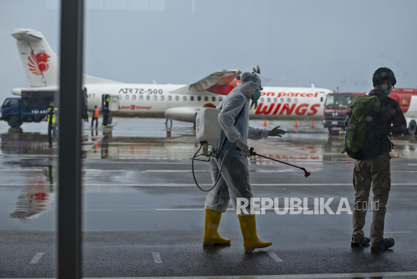 Petugas menyemprotkan cairan disinfektan pada penumpang pesawat komersial Wings Air asal Batam usai mendarat di Bandara Raden Sadjad, Ranai, Kabupaten Natuna, Kepulauan Riau, Selasa (17/11/2020). Selama masa pandemi COVID-19 hanya ada dua maskapai penerbangan yang melayani penumpang di bandara tersebut, antara lain Wings Air dengan jadwal sekali dalam sehari pada Senin hingga Sabtu dan Sriwijaya Air sekali dalam seminggu setiap Senin, dengan rute dari dan ke Bandara Hang Nadim Batam, Kepri. 