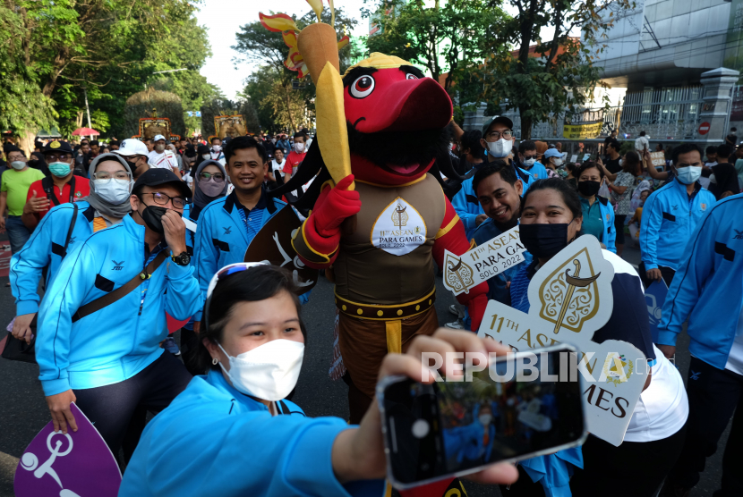 Peserta berfoto dengan relawan berkostum maskot ASEAN Para Games XI 2022 saat peluncuran logo dan maskot tersebut di Jalan Slamet Riyadi, Solo, Jawa Tengah, Ahad  (3/7/2022). Indonesia menjadi tuan rumah ajang ASEAN Para Games XI 2022 yang akan diikuti 11 negara Asia Tenggara pada 30 Juli-6 Agustus 2022 di Solo, Jawa Tengah. 