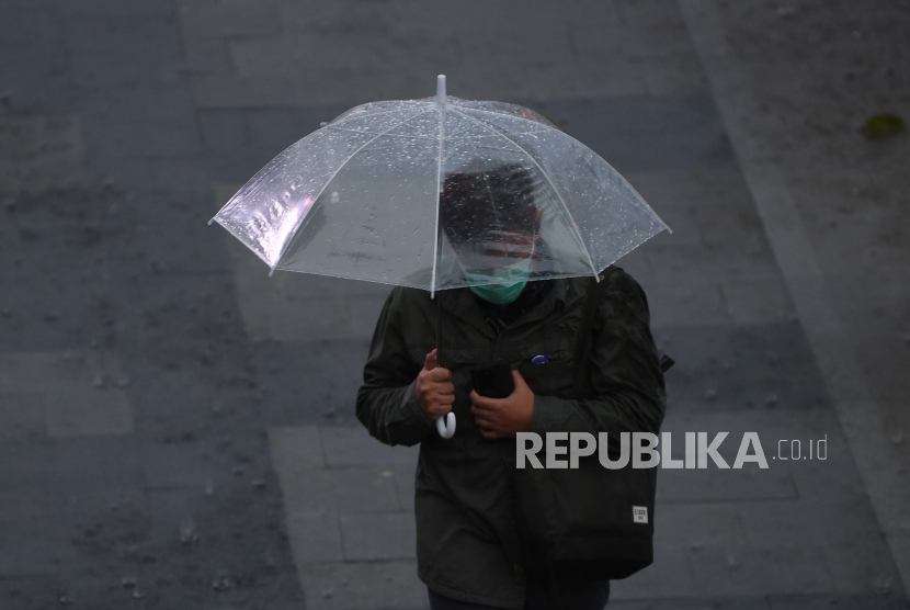 Seorang warga membawa payung saat melintas di Kawasan Senayan, Jakarta. Badan Meteorologi Klimatologi dan Geofisika (BMKG) mengingatkan warga Jakarta untuk mewaspadai potensi hujan disertai petir pada Selasa, (3/11).