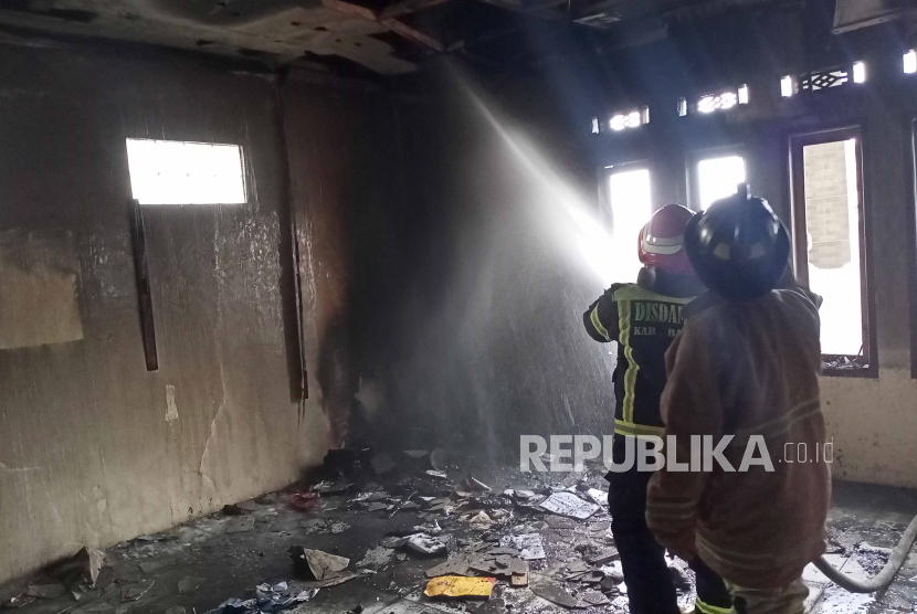 Petugas pemadam kebakaran (damkar) melakukan penanganan di ruang kantor Lembaga Pemberdayaan Masyarakat Desa (LPMD) Ibun, Kabupaten Bandung, yang terbakar, Senin (11/9/2023). 