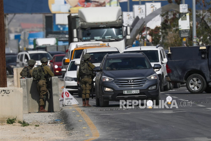  Tentara Israel memeriksa mobil Palestina di sebuah pos pemeriksaan di pintu masuk kota Jericho di Tepi Barat, 28 Februari 2023.
