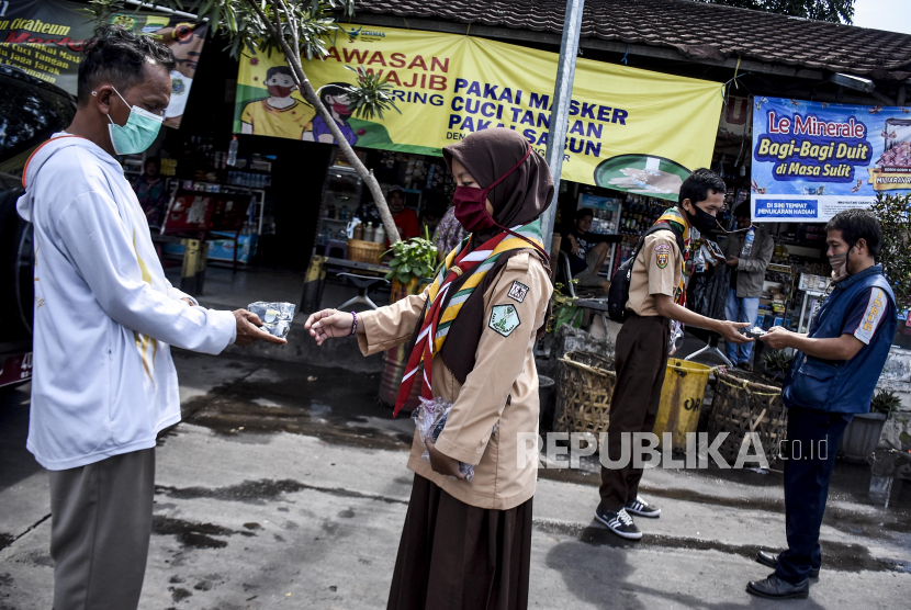 FKUI: Sebagian Masyarakat Belum Teredukasi Covid-19. Sejumlah pelajar memberikan masker kepada warga saat Kampanye Penggunaan Masker di Terminal Cicaheum, Kota Bandung, Selasa (3/11). Kampanye tersebut sebagai ajakan kepada masyarakat untuk membiasakan diri memakai masker agar terhindar dari penularan Covid-19. Foto: Abdan Syakura/Republika