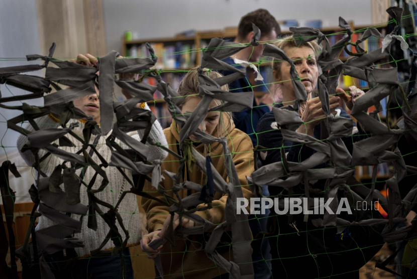 Relawan Ukraina membuat simpul kain untuk membuat jaring kamuflase di Lviv, Ukraina barat, Senin, 28 Februari 2022. 