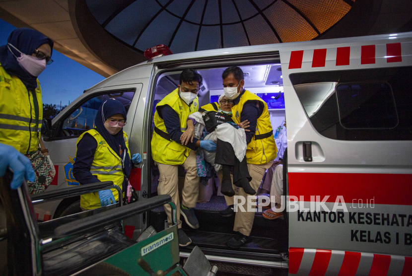 Petugas membantu seorang haji lansia turun dari mobil ambulans setibanya di Asrama Haji Batam, Kepulauan Riau, Selasa (4/7/2023)malam. Sebanyak 369 jamaah haji kloter pertama asal Kepri telah kembali setelah menunaikan ibadah haji.