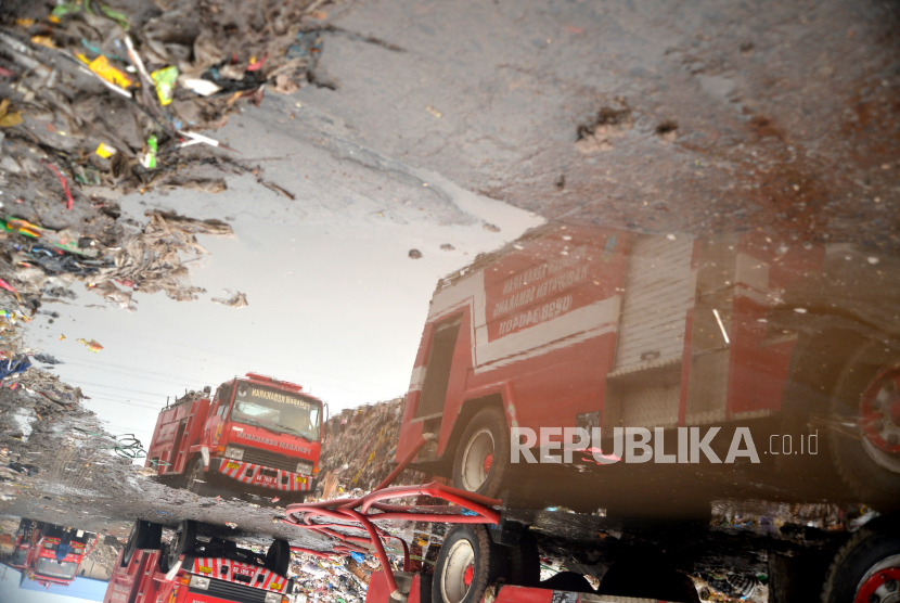 Petugas pemadam kebakaran gabungan memadamkan kebakaran di Tempat Pembuangan Akhir (TPA) Putri Cempo, Mojosongo, Surakarta, Jawa Tengah, Ahad (17/9/2023). Blok B TPA Putri Cempo terbakar pada Sabtu (16/9/2023) siang sekitar pukul 13.00 WIB yang dipicu oleh cuaca panas yang tinggi menyebabkan tumpukan gas metana terbakar. Pemadaman dilakukan secara gabungan yang melibatkan petugas pemadam kebakaran dari DIY dan Kabupaten lain di Jawa Tengah. Hingga Ahad (17/9/2023) beberapa titik api dan kepulan asap tebal masih terlihat di lokasi kebakaran.