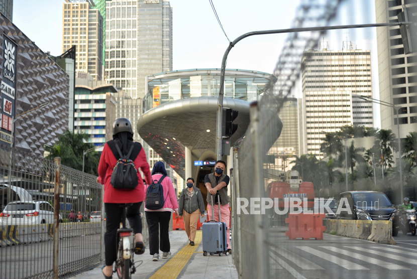 Pekerja berjalan saat jam pulang kerja di kawasan bisnis Sudirman, Jakarta, Selasa (20/12/2022). Menteri Ketenagakerjaan (Menaker) Ida Fauziah mengatakan, keberhasilan Jepang sebagai negara maju karena kemampuan baik dalam mengelola bonus demografinya.