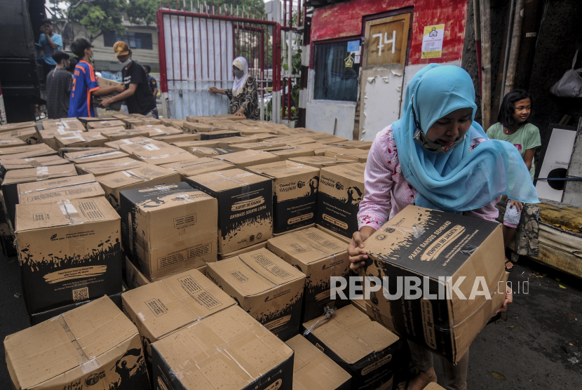 Sejumlah warga membawa paket bantuan sosial di kawasan Balimester, Jakarta, Kamis (5/11). 
