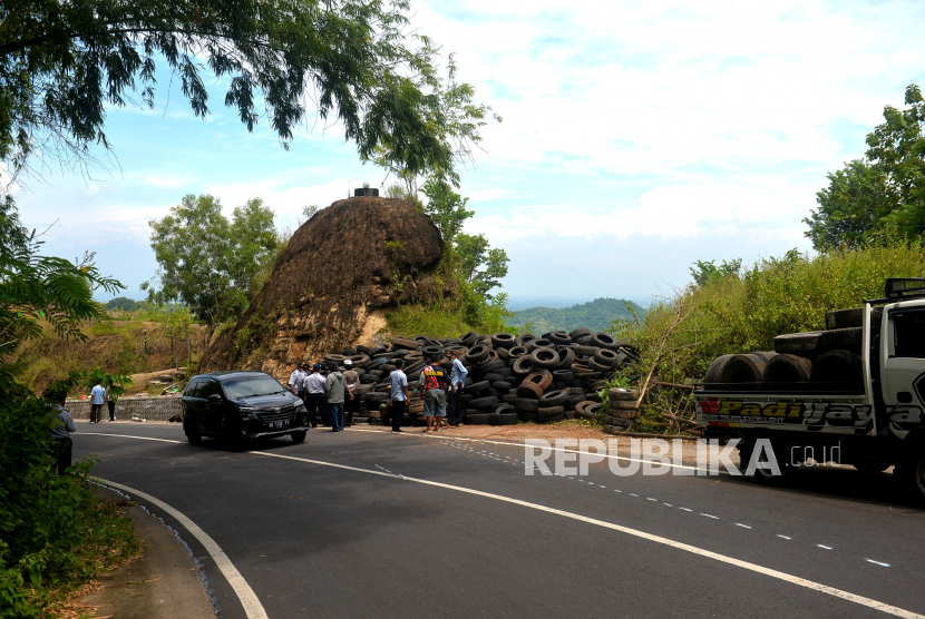Relawan membongkar ban bekas untuk dinding pengaman di lokasi kecelakaan bus pariwisata, Bukit Bego, Imogiri, Bantul, Yogyakarta, Selasa (8/2/2022). Jalan ini memang dikenal rawan kecelakaan. 