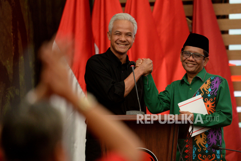 Bakal calon presiden Ganjar Pranowo berjabat tangan dengan Bakal calon wakil presiden Mahfud MD. Pengamat sebut masuknya Mahfud MD ke Ganjar bisa menghindarkan politik identitas.