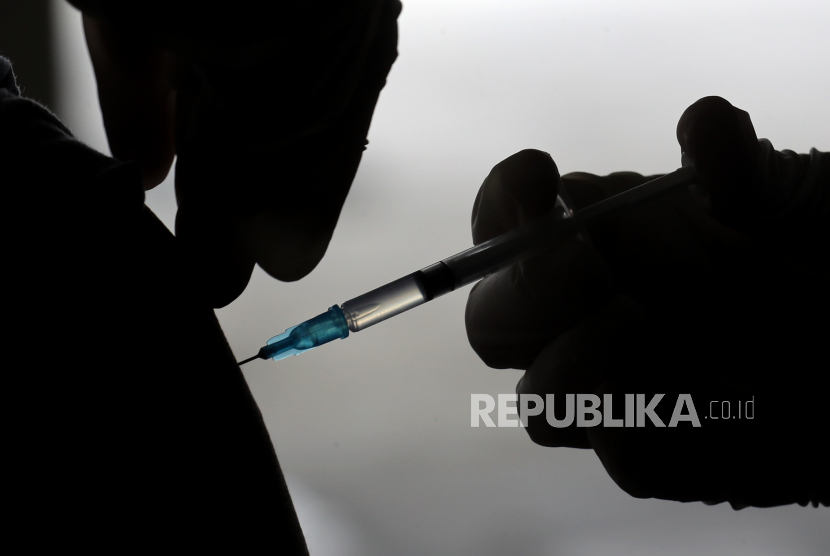 Seorang petugas kesehatan Indonesia menyuntikkan satu dosis vaksin Sinovac COVID-19 kepada orang berusia 18 tahun ke atas selama kampanye vaksinasi COVID-19 di tempat parkir Rumah Sakit Universitas Indonesia (RSUI) di Jakarta, Indonesia, 16 Juni 2021. 