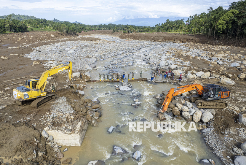 Foto udara pekerja menggunakan alat berat untuk membangun jalan darurat di aliran Sungai Nanggang, Nagari Salareh Aia Timur, Palembayan, Agam, Sumatera Barat, Ahad (7/12/2025). Pemerintah menurunkan beberapa alat berat di sejumlah titik jalan yang terdampak bencana banjir bandang guna mempercepat pendistribusian logistik kepada para penyintas. 