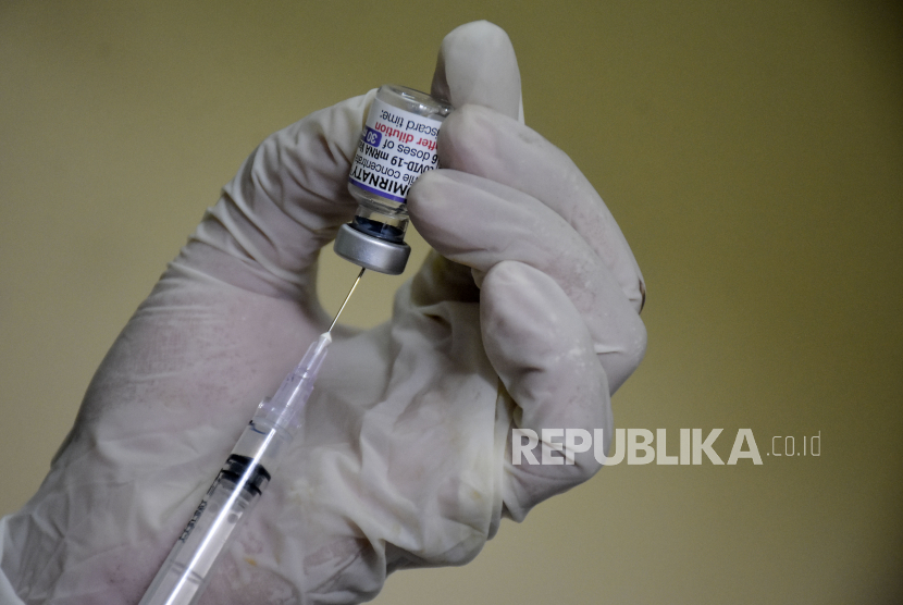 Vaksinator menyiapkan vaksin Covid-19 dosis keempat untuk disuntikkan ke warga.