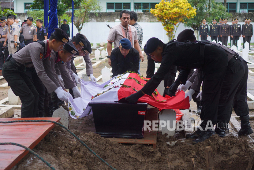 Anggota Polri memakamkan jenazah Bharatu (Anumerta) Doni Priyatno yang gugur di Papua, di Taman Makam Pahlawan (TMP) Trenggalek, Jawa Timur, Ahad (1/03/). 