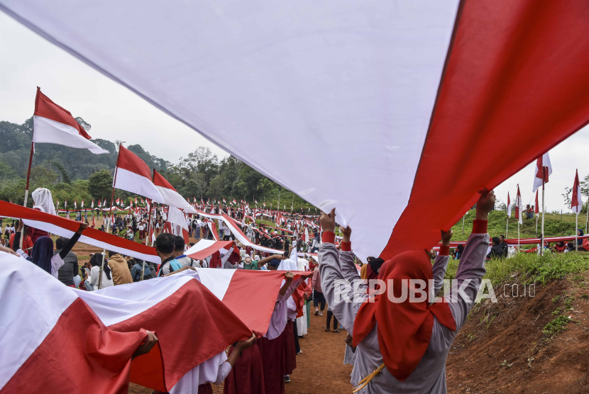 Sejumlah warga membentangkan bendera bertemakan Langkaplancar Berkibar Untuk Indonesia di Sirkuit Serdadu, Kecamatan Langkaplancar, Kabupaten Pangandaran, Jawa Barat, Sabtu (19/8/2023). Kirab Bendera Merah Putih sepanjang 4.000 meter dan 1.500 tiang bendera itu digelar oleh warga secara swadaya dalam rangka memeriahkan HUT ke-78 RI. 