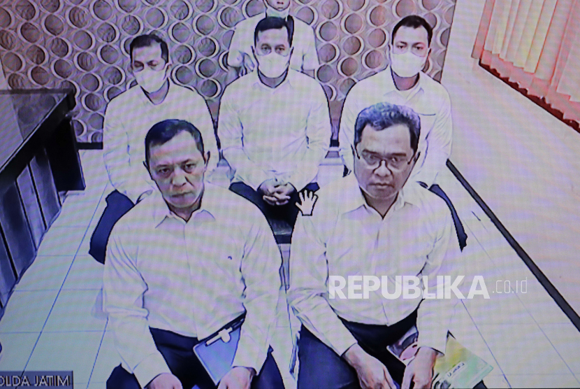  Para terdakwa dihadirkan secara virtual di layar selama persidangan pertama penyerbuan maut stadion Kanjuruhan di gedung pengadilan di Surabaya, Jawa Timur, Senin (16/1/2023). 