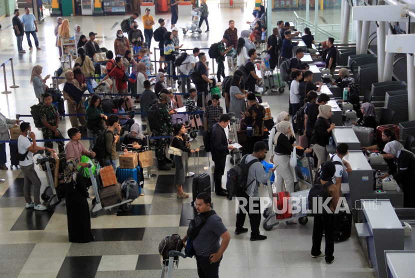 Calon penumpang pesawat antre untuk melaporkan diri di Bandara Internasional Kualanamu, Kabupaten Deli Serdang, Sumatera Utara, Ahad (14/4/2024). PT Angkasa Pura Aviasi mencatat jumlah penumpang arus balik Lebaran 2024 pada H+3 sebanyak 22.061 orang diataranya 9.928  kedatangan dan 12.133 keberangkatan. 
