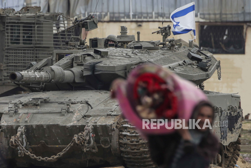 Pengungsi Palestina bergerak melewati tank Israel di Jalur Gaza selatan, 27 Januari 2024