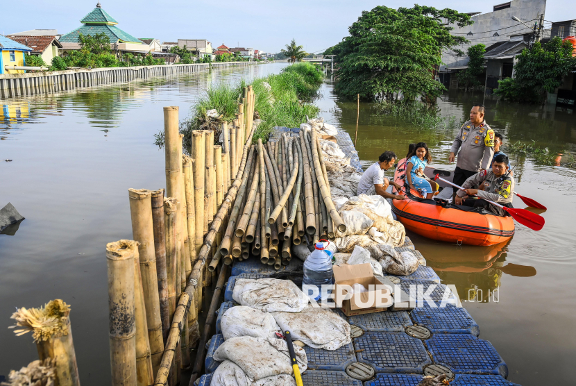 Kapolsek Jati Uwung Polres Metro Tangerang Kota Kompol Robiin bersama warga meninjau turap yang jebol saat banjir merendam Perumahan Garden City Residence, Periuk, Kota Tangerang, Banten, Ahad (24/11/2024). Banjir merendam ratusan rumah warga sejak Sabtu (23/11/2024) malam yang disebabkan jebolnya turap kali sepanjang 10 meter. 