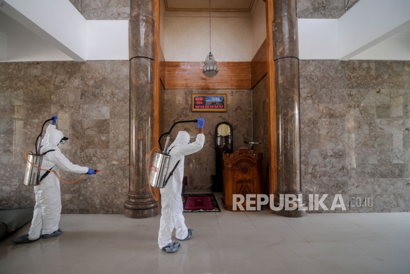 Petugas Dinas Pangan dan Pertanian Kota Cimahi menyemprotkan cairan disinfektan di Masjid Agung Cimahi Utara, Jawa Barat, Selasa (17/3/2020). Penyemprotan disinfektan di setiap sudut masjid yang sering digunakan oleh jamaah tersebut dilakukan sebagai upaya untuk mencegah penyebaran virus Corona (COVID-19) yang telah ditetapkan sebagai pandemik oleh WHO. ANTARA FOTO/Raisan Al Farisi/hp.(Antara/Raisan Al Farisi)