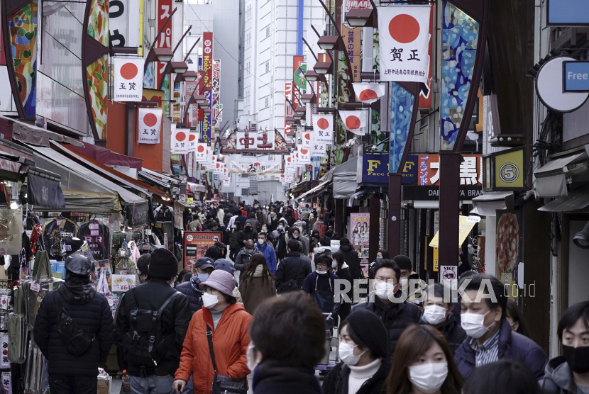  Orang-orang yang mengenakan masker pelindung untuk membantu mengekang penyebaran virus corona berjalan di sepanjang jalan perbelanjaan di daerah Ueno, Tokyo Senin, 11 Januari 2021. Kementerian Kesehatan Jepang pada Ahad (14/2/2021) resmi merestui penggunaan vaksin Covid-19 buatan Pfizer. 