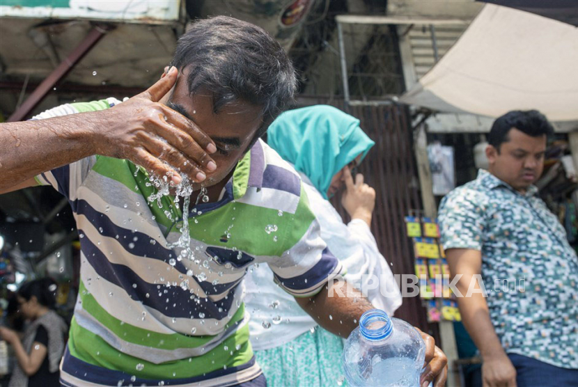  Seorang pria memercikkan air ke wajahnya untuk mendinginkan diri saat cuaca panas di kawasan Universitas Dhaka di Dhaka, Bangladesh, Senin (17/4/2023). 