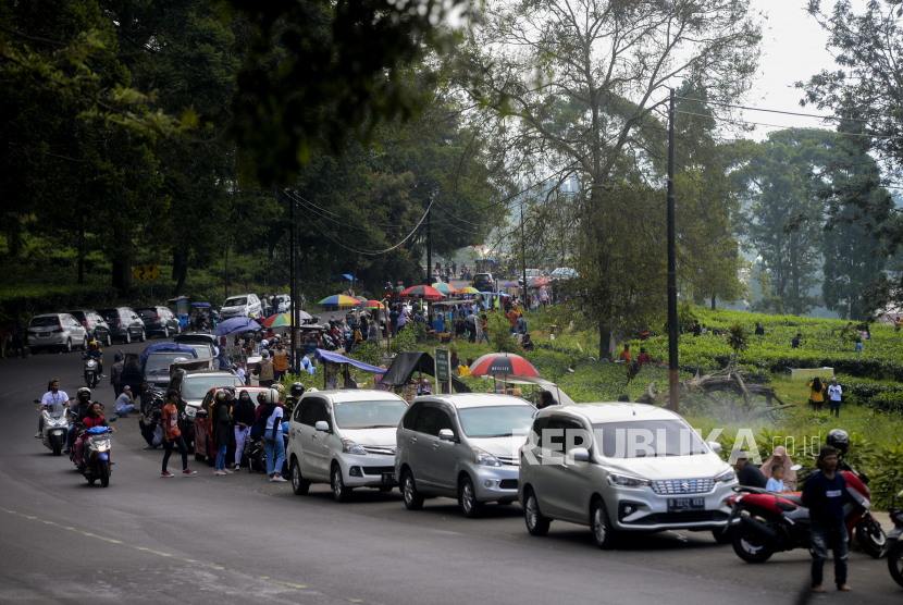 Sejumlah warga berwisata di kawasan kebun teh Puncak, Bogor, Jawa Barat, Sabtu (30/5). Meskipun dalam masa Pembatasan Sosial Berskala Besar (PSBB) kawasan Puncak tetap ramai dikunjungi wisatawan